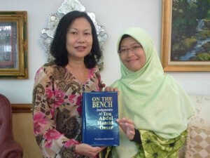 Cik Wan Nur Shazwani receiving a copy of the Judgements of the late Tun Abdul Hamid from YTAH Director, Puan Ellina